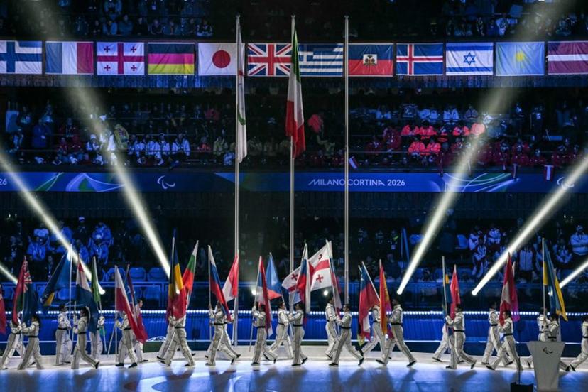 Volunteers parade with flags of countries during the Milano Cortina 2026 Winter Paralympic Games closing ceremony at the Olympic Ice Stadium in Cortina d'Ampezzo, on March 15, 2026. Jeff PACHOUD / AFP