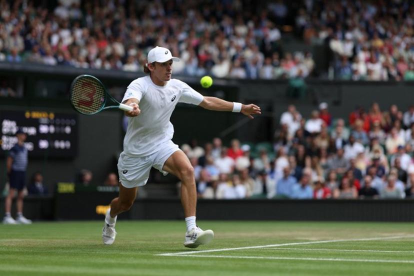 Australia's Alex De Minaur plays a forehand return to Serbia's Novak Djokovic during their men's singles fourth round tennis match on the eighth day of the 2025 Wimbledon Championships at The All England Lawn Tennis and Croquet Club in Wimbledon, southwest London, on July 7, 2025. Adrian Dennis / AFP