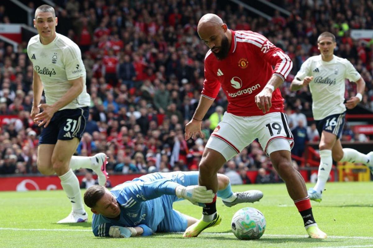 Manchester United's Cameroonian midfielder #19 Bryan Mbeumo (R) takes the ball around Nottingham Forest's Belgian goalkeeper #26 Matz Sels during the English Premier League football match between Manchester United and Nottingham Forest at Old Trafford in Manchester, north west England, on May 17, 2026. Darren Staples / AFP