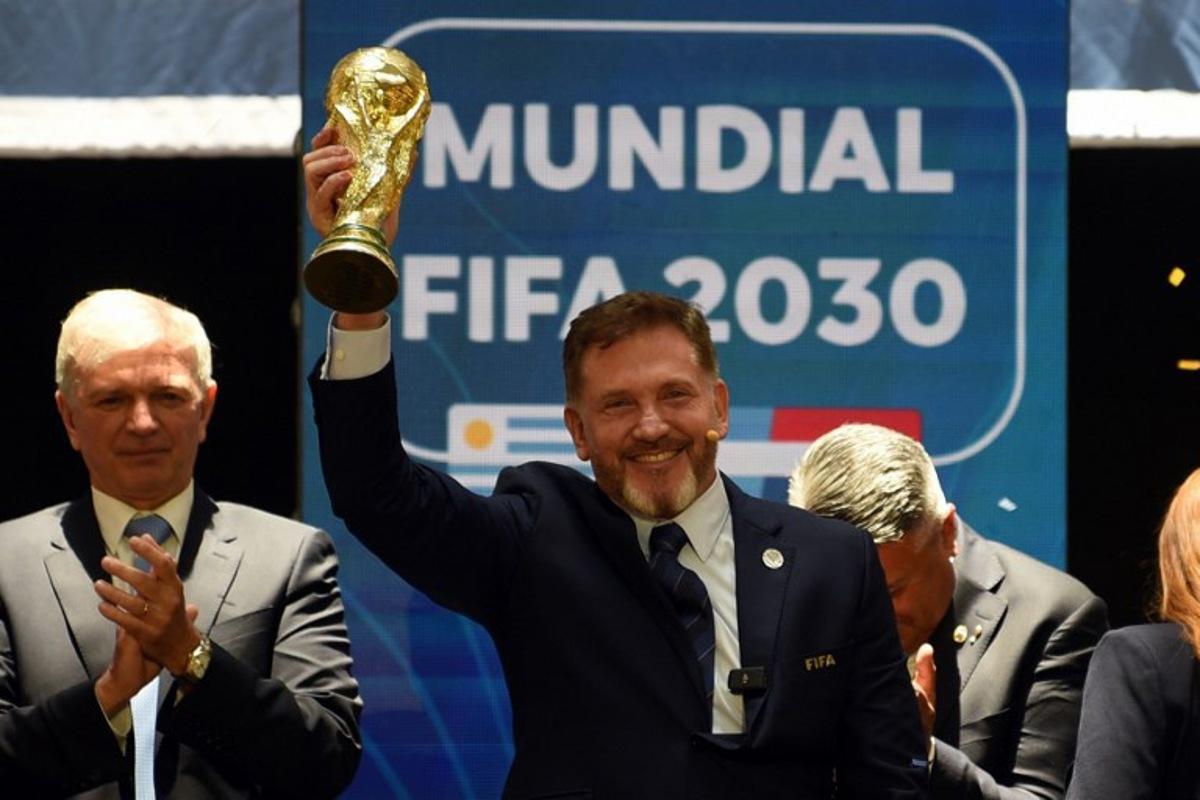 CONMEBOL President Paraguayan Alejandro Dominguez holds a replica of the FIFA World Cup as he celebrates the ratification of Argentina, Paraguay, and Uruguay as host countries of the FIFA 2030 World Cup during the FIFA virtual Congress in Luque, Paraguay, on December 11, 2024. A virtual Congress of world football's governing body confirmed that Morocco, Spain and Portugal will be joint hosts of the 2030 World Cup, which will also see three games played in South America. The 2030 tournament will mark a century since the first World Cup was held in Uruguay, and as a result the unrivalled joint bid by Morocco, Spain and Portugal will also see the South American nation handed one game along with Argentina and Paraguay. DANIEL DUARTE / AFP