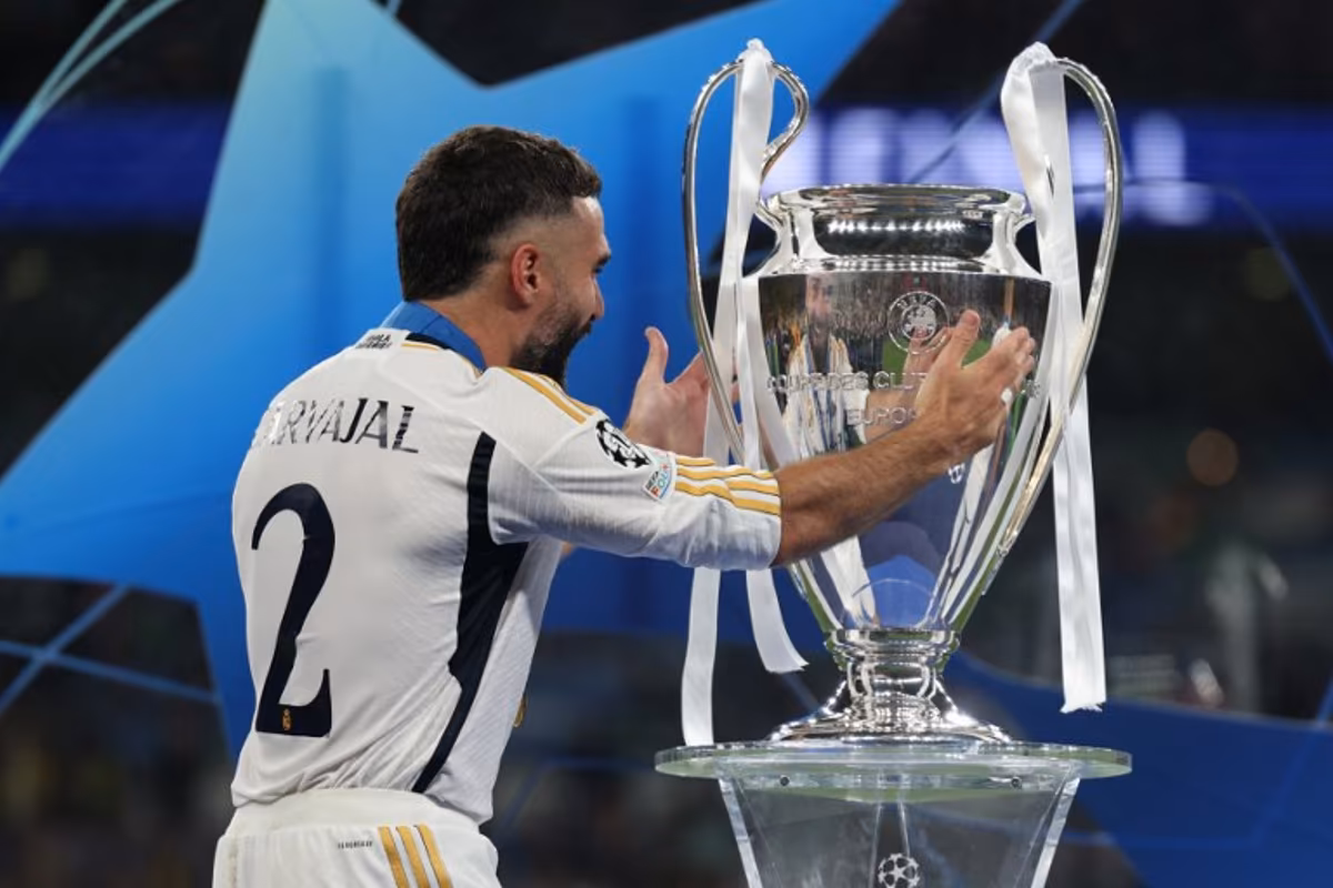 Real Madrid's Spanish defender #02 Dani Carvajal touches the trophy as he celebrates after winning the UEFA Champions League final football match between Borussia Dortmund and Real Madrid, at Wembley stadium, in London, on June 1, 2024. Real Madrid wins the Champions League final 2 - 0 against Borussia Dortmund. Adrian DENNIS / AFP