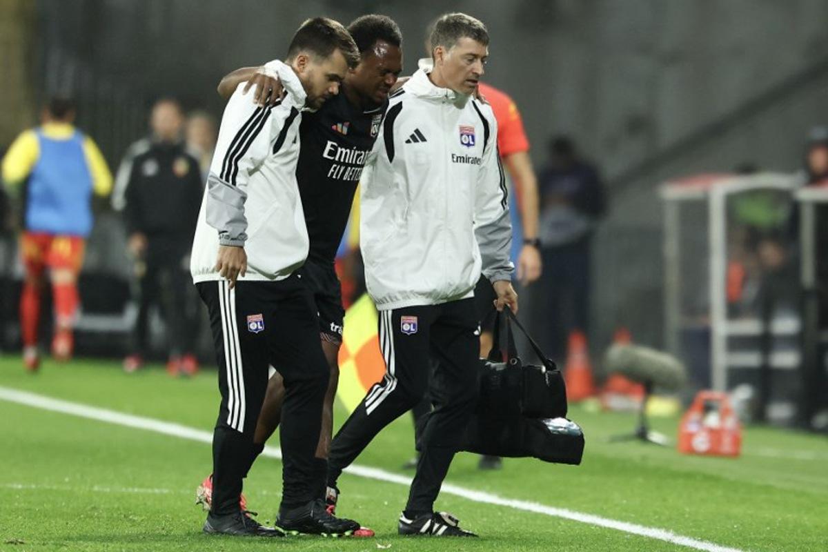 Lyon's Belgian forward #17 Lois Openda leaves the pitch due to an injury during the French L1 football match between RC Lens and Olympique Lyonnais (OL) at the Stade Bollaert-Delelis in Lens, northern France, on October 9, 2026. Sameer AL-DOUMY / AFP
