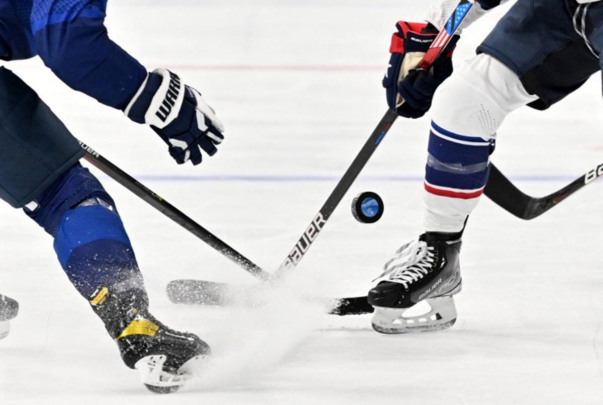 USA's Jessica Compher (R) vies for the puck with Finland's Minnamari Tuominen during their women's preliminary round group A match of the Beijing 2022 Winter Olympic Games ice hockey competition, at the Wukesong Sports Centre in Beijing on February 3, 2022. Anthony WALLACE / AFP