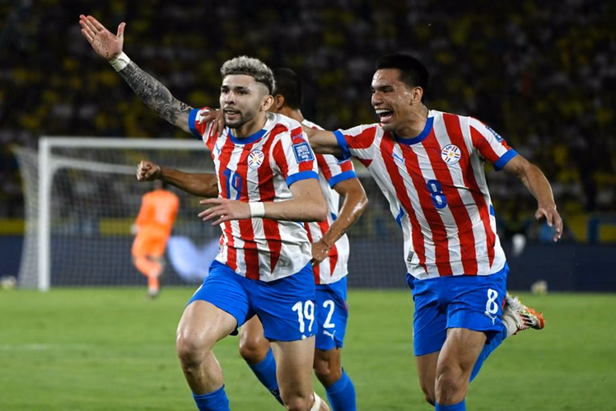 Paraguay's forward #19 Julio Enciso (L) celebrates next to teammate midfielder #08 Diego Gomez after scoring his team second goal during the 2026 FIFA World Cup South American qualifiers football match between Colombia and Paraguay at the Metropolitano Roberto Melendez stadium in Barranquilla, Colombia, on March 25, 2025. Luis ACOSTA / AFP