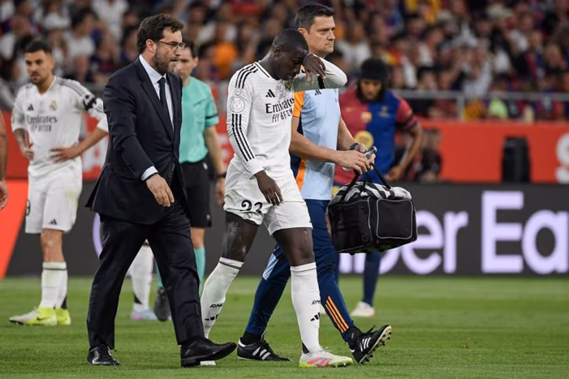 Real Madrid's French defender #23 Ferland Mendy leaves the pitch after resulting injured during the Spanish Cup, Copa del Rey (King's Cup) final football match between FC Barcelona and Real Madrid CF at La Cartuja stadium in Seville on April 26, 2025. Josep LAGO / AFP