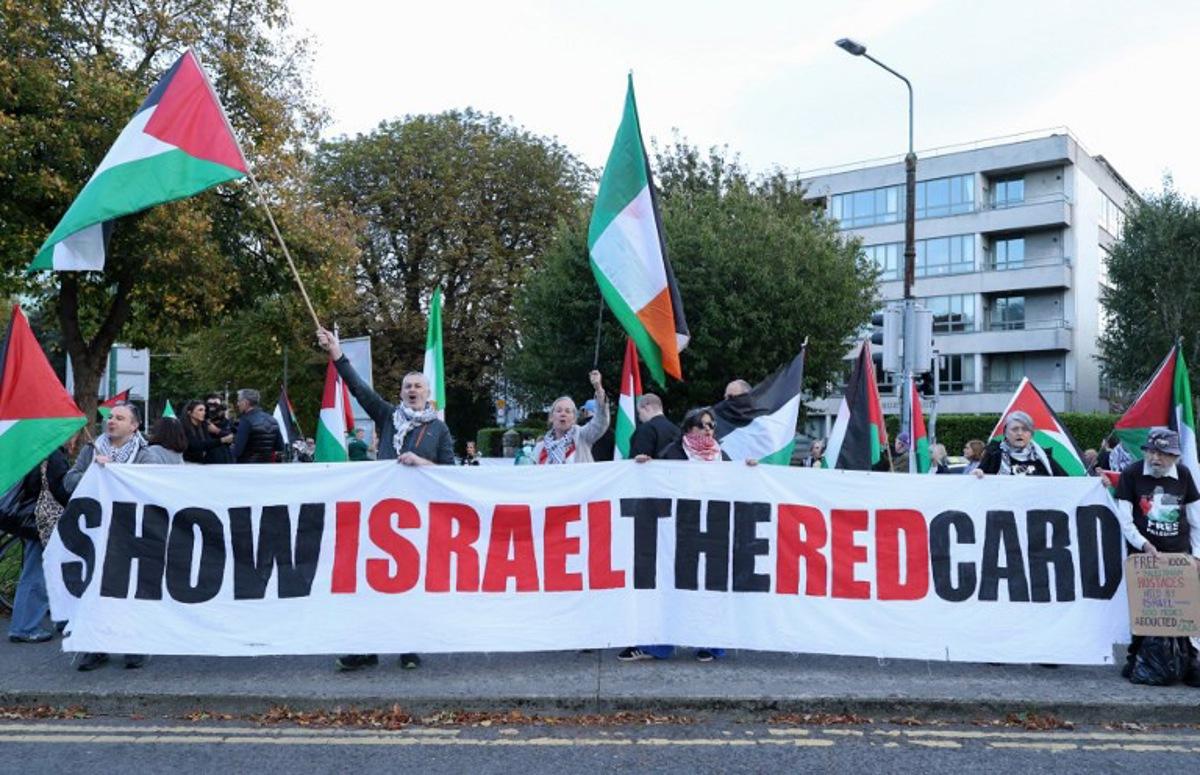 People hold placards calling on Ireland's football team not to play their next fixture against Israel, during a 'Stop The Game' protest outside Aviva Stadium in Dublin on October 1, 2026, ahead of the team's Nations League match against Austria. Ireland coach Heimir Hallgrimsson said on September 30 they will play their second Nations League match against Israel on October 4 after the first fixture was thrown into doubt by player concerns over the Gaza war. Paul Faith / AFP