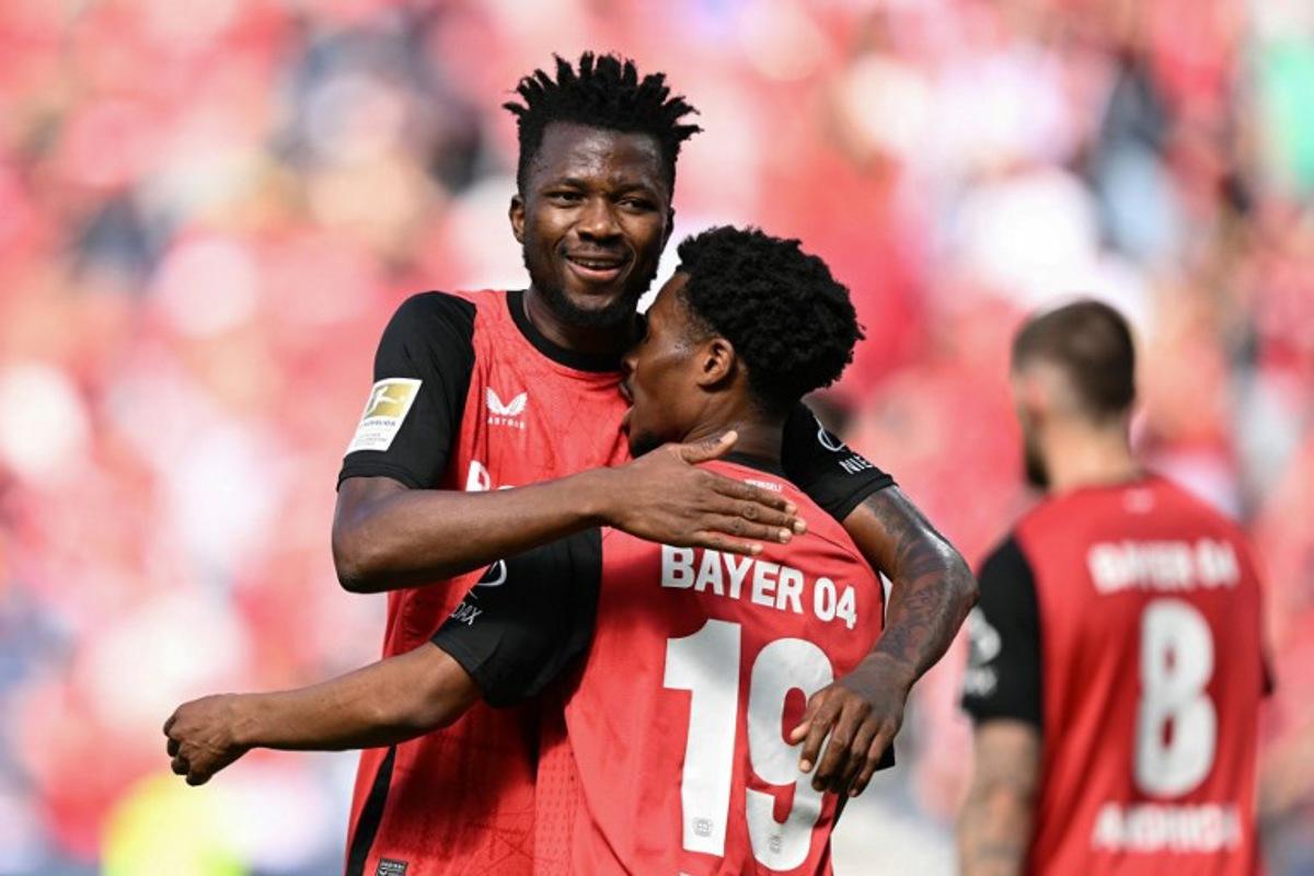 Bayer Leverkusen's English midfielder #19 Nathan Tella (front) celebrates the opening goal with team mate Bayer Leverkusen's Nigerian forward #22 Victor Boniface during the German first division Bundesliga football match between Bayer 04 Leverkusen and FC Augsburg in Leverkusen, western Germany on April 26, 2025. INA FASSBENDER / AFP