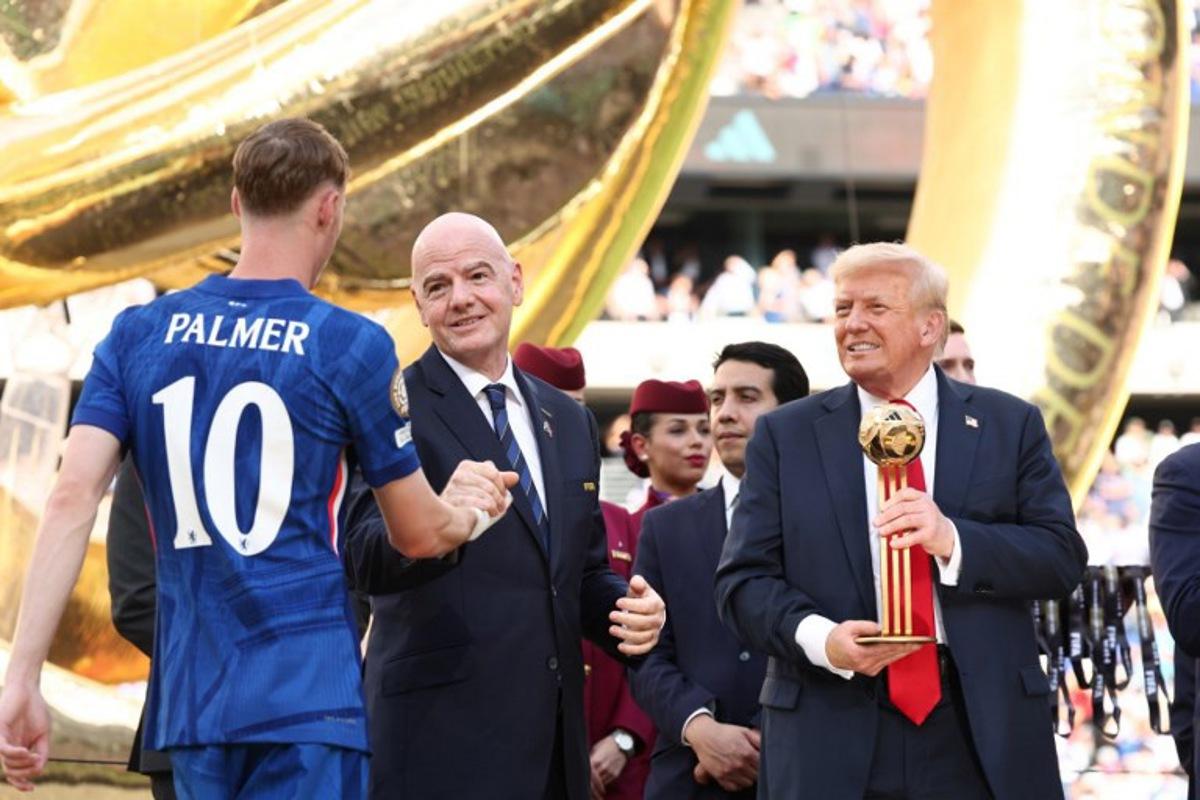 FIFA president Gianni Infantino and US President Donald Trump present Chelsea's English midfielder #10 Cole Palmer with the golden ball trophy after Chelsea won against Paris St Germain in the FIFA Club World Cup final, at the MetLife Stadium in East Rutherford, New Jersey on July 13, 2025. KEVIN LAMARQUE / POOL / AFP