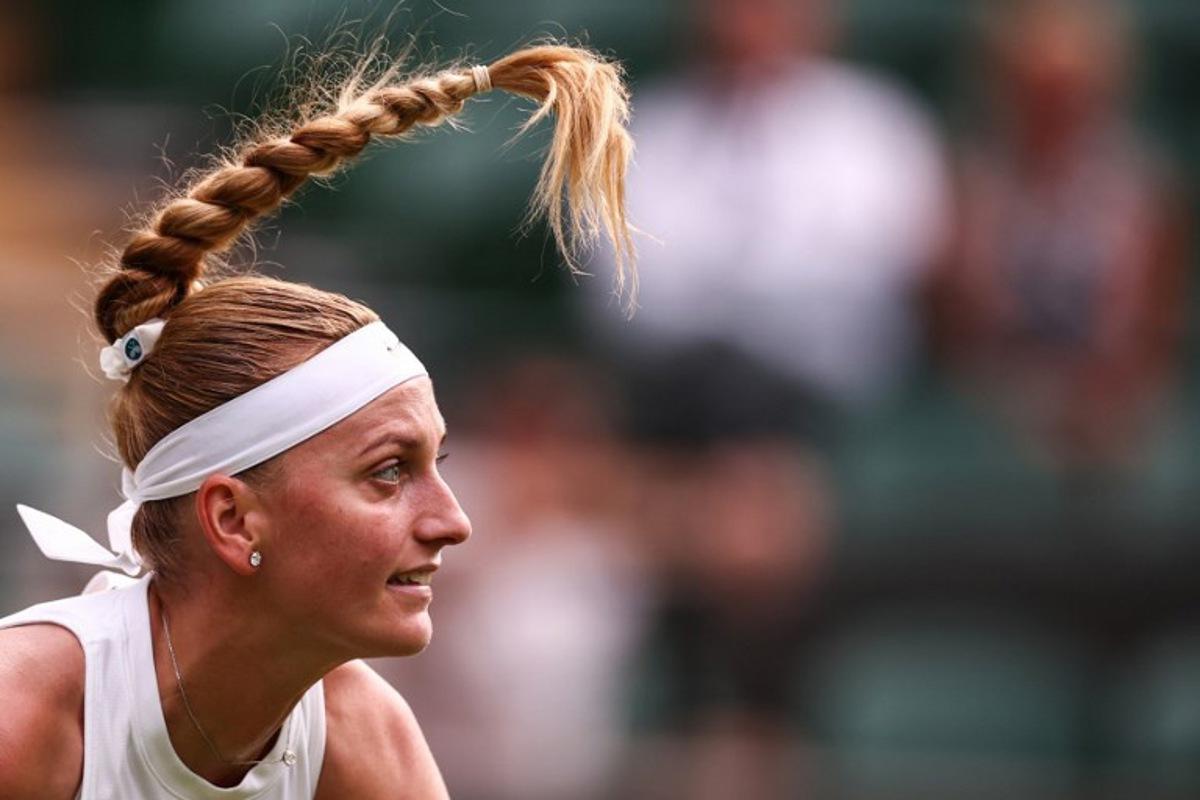 The hair of Czech Republic's Petra Kvitova move over head as she serves the ball to US player Emma Navarro during their women's singles first round tennis match on the second day of the 2025 Wimbledon Championships at The All England Lawn Tennis and Croquet Club in Wimbledon, southwest London, on July 1, 2025. HENRY NICHOLLS / AFP