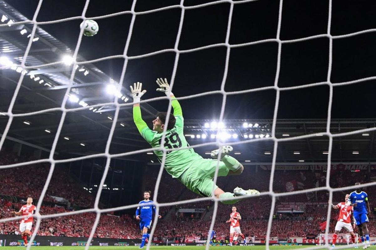 Strasbourg's Belgian goalkeeper #39 Mike Penders (L) fails to save the first goal by Mainz' Japanese midfielder #06 Kaishu Sano (not pictured) during the UEFA Europa Conference League quarter-final first leg football match between 1 FSV Mainz 05 and RC Strasbourg Alsace in Mainz, western Germany on April 9, 2026. Kirill KUDRYAVTSEV / AFP