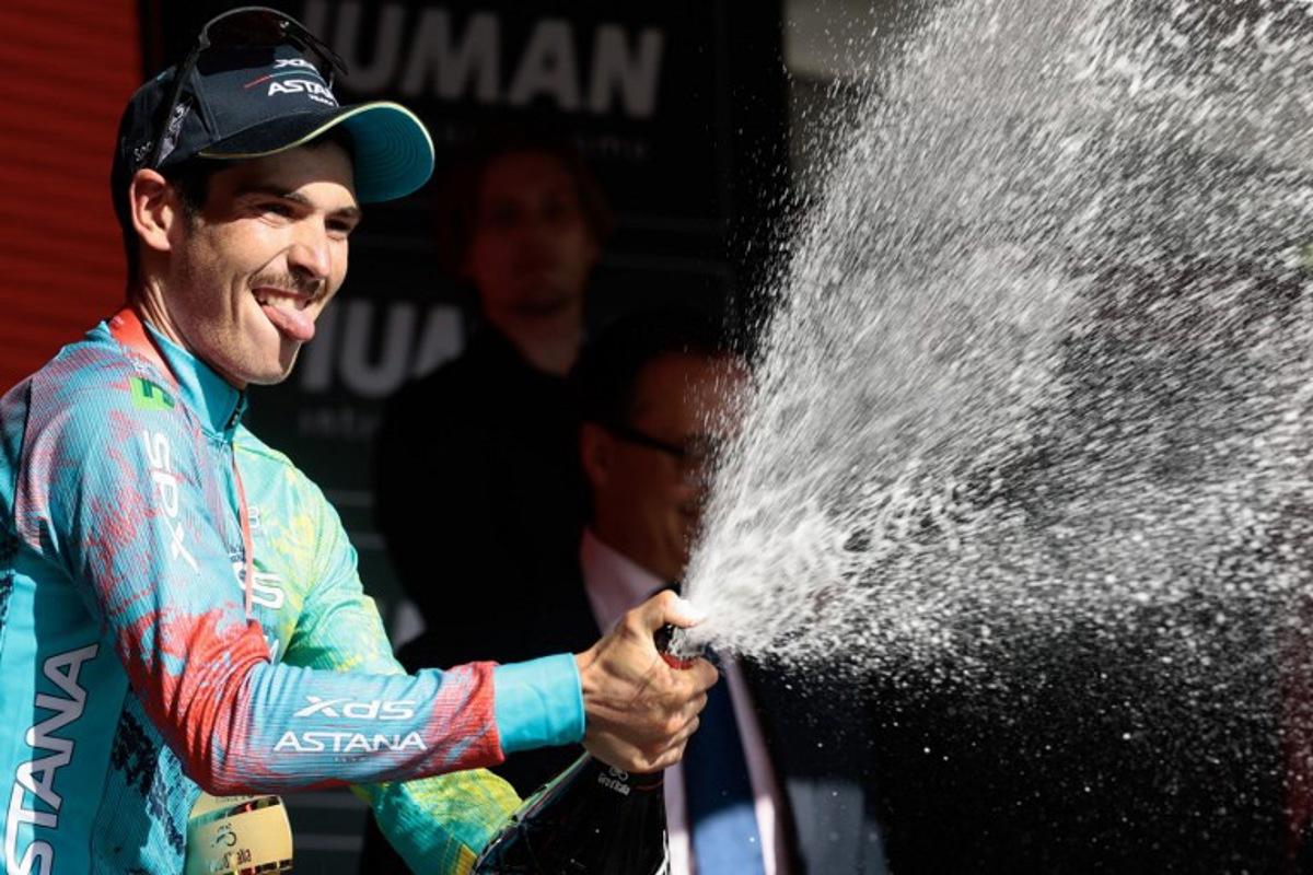 XDS Astana Team's Italian rider Christian Scaroni sprays champagne as he celebrates on the podium after victory in the 16th stage of the 108th Giro d'Italia cycling race of 203kms from Piazzola sul Brenta to San Valentino on May 27, 2025. Luca Bettini / AFP