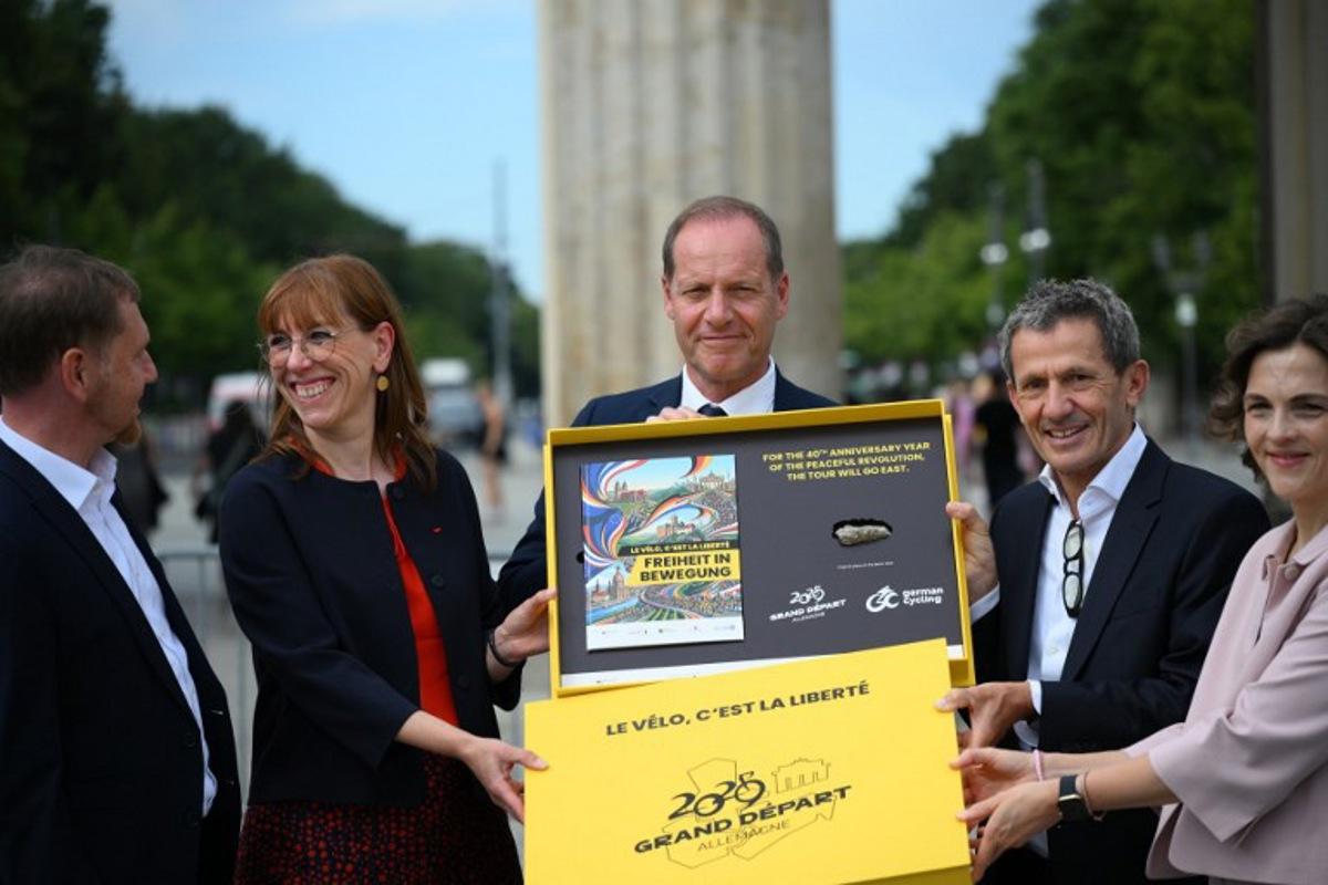 Tour de France director Christian Prudhomme (C) poses for a group photo with the bid for the 2029 Tour de France (TDF) departure in Berlin, in front of landmark Brandenburg Gate with (L-R) Saxony's State Premier Michael Kretschmer, Member of the Saxon State Parliament Katja Meier, ASO (Amaury Sport Organisation)'s CEO Yann Le Moenner and government's commissionner for Eastern Germany Elibeth Kaiser (R) in Berlin, Germany, on July 29, 2026. RALF HIRSCHBERGER / AFP