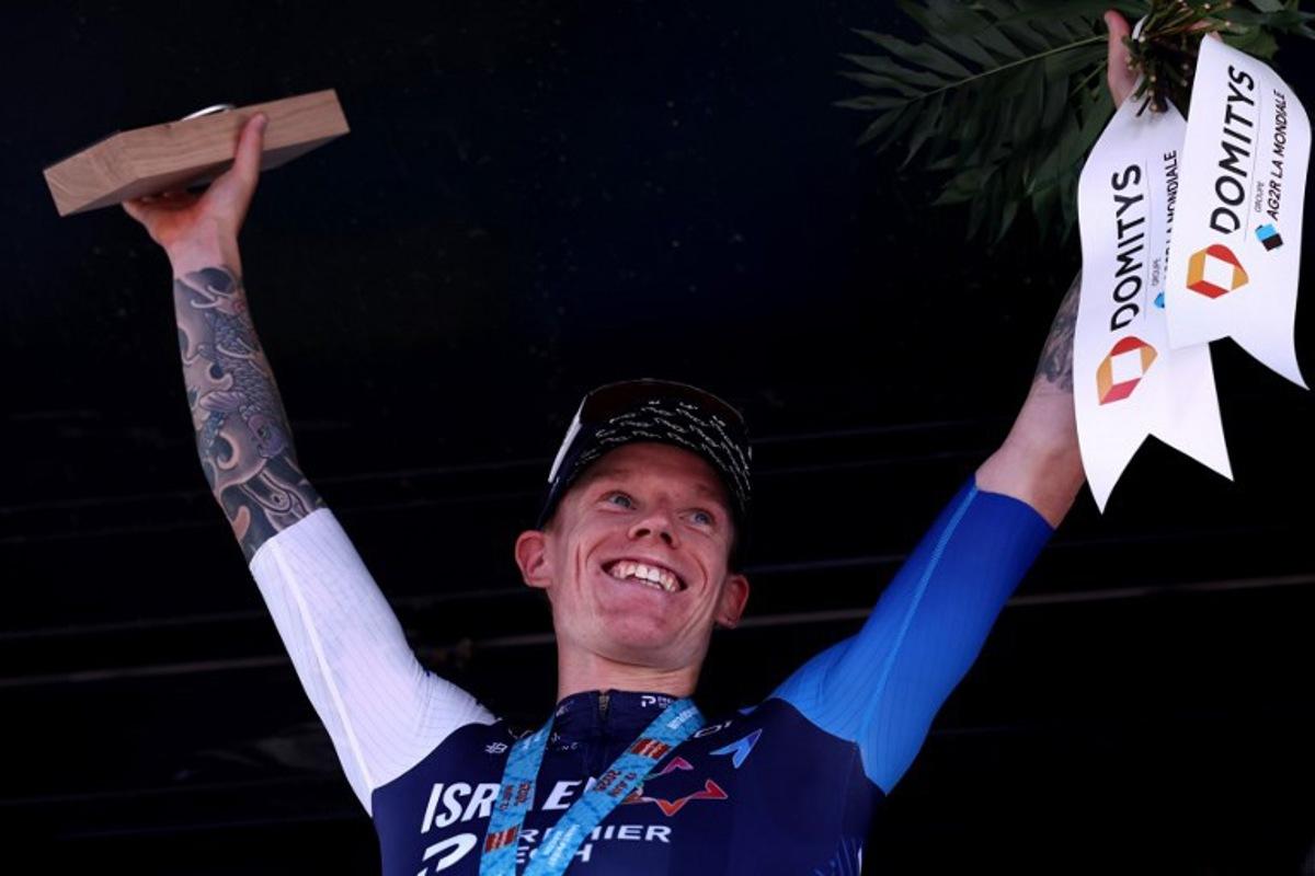 Israel - Premier Tech's British rider Thomas Jake Stewart celebrates winning the stage on the podium of the 5th stage of the 77th edition of the Criterium du Dauphine cycling race, 183 km between Saint-Priest and Mâcon, on June 12, 2025. Anne-Christine POUJOULAT / AFP