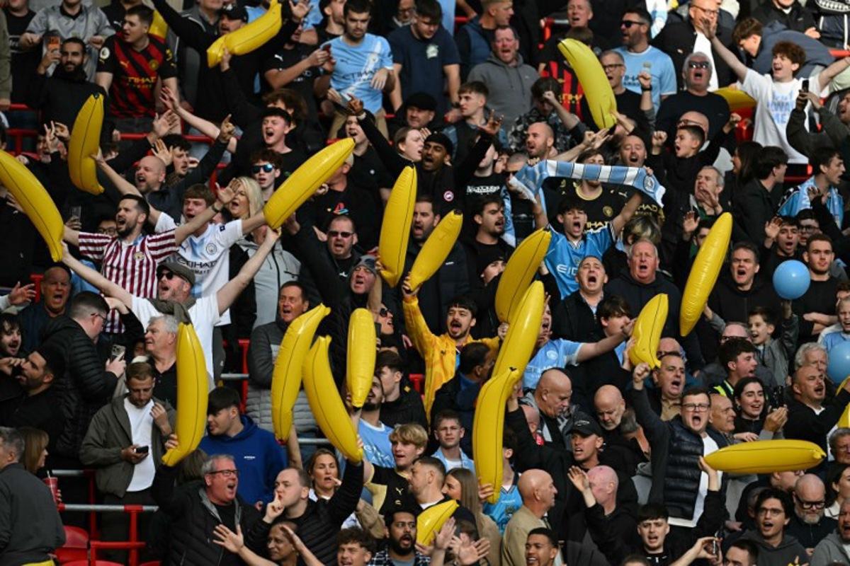 City fans wave inflatable bananas in the crowd ahead of the English Premier League football match between Liverpool and Manchester City at Anfield in Liverpool, north west England on October 11, 2026. Paul ELLIS / AFP