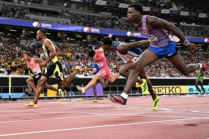 Athletes including US' athlete Ja'Kobe Tharp (R) and Jamaica's athlete Orlando Bennett (2nd L) cross the finish line in the men's 110m hurdles heats during the World Athletics Championships in Tokyo on September 15, 2025. Jewel SAMAD / AFP