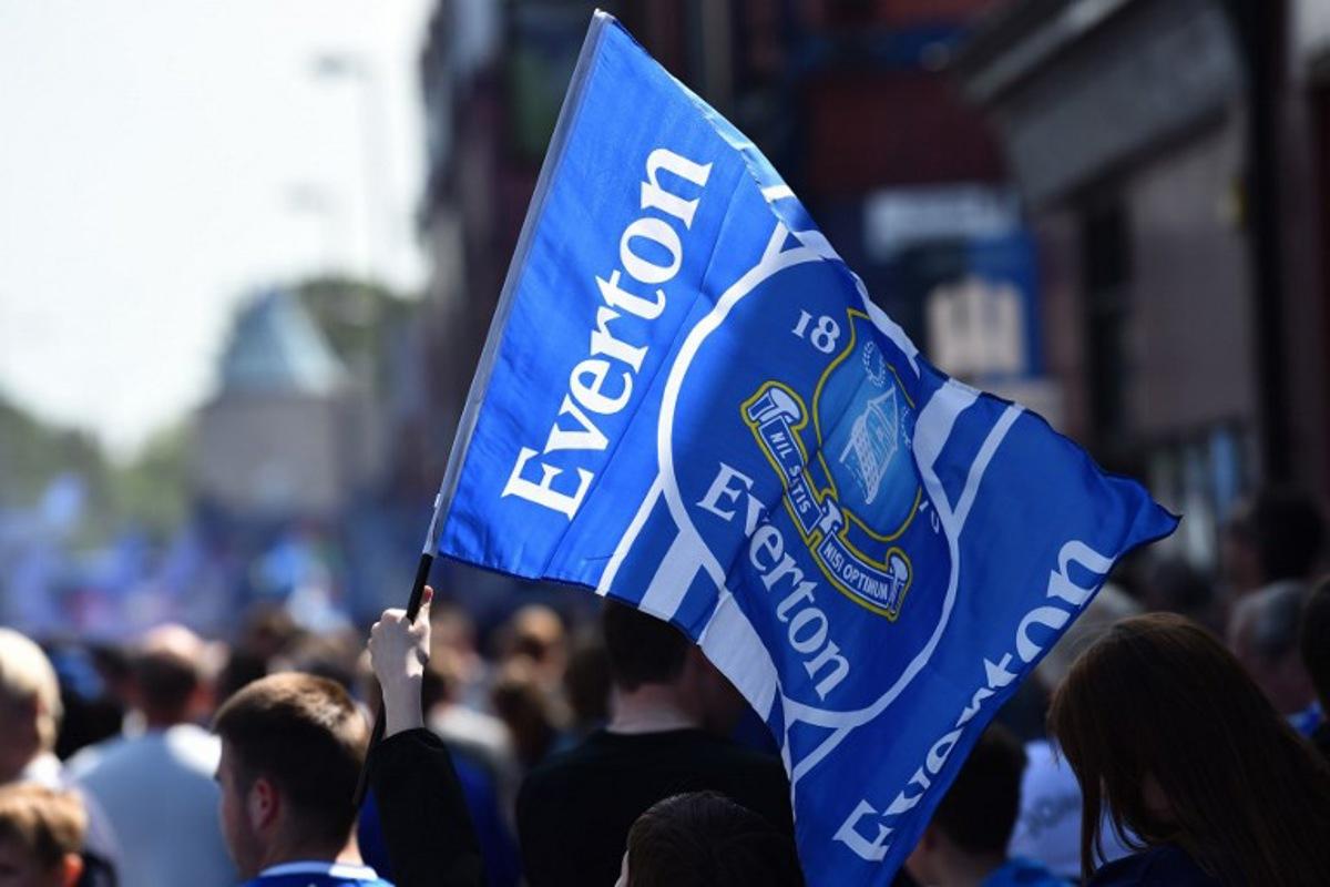Everton supporters wave the club's flag before the start of the English Premier League football match between Everton and Bournemouth at Goodison Park in Liverpool, north west England on May 28, 2023. PETER POWELL / AFP