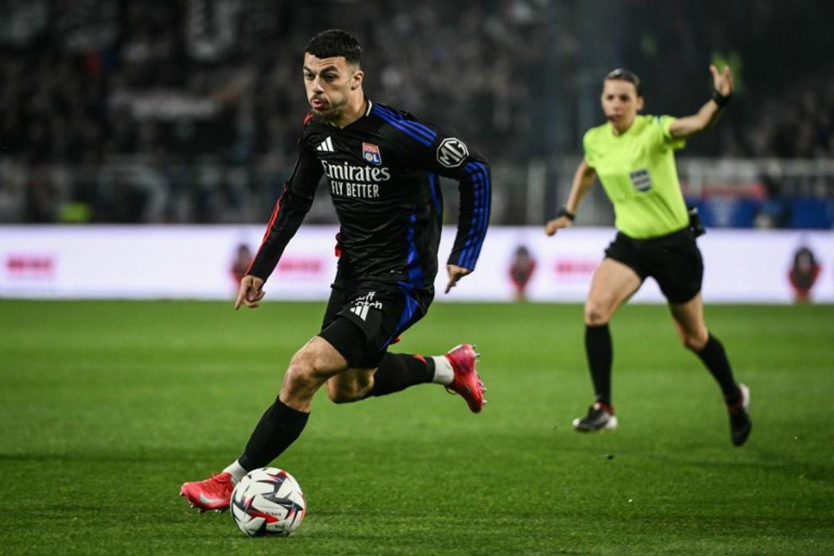 Lyon's Georgian forward #69 Georges Mikautadze runs with the ball during the French L1 football match between AJ Auxerre and Olympique Lyonnais (OL) at Stade de l'Abbe-Deschamps in Auxerre, central France, on April 13, 2025. ARNAUD FINISTRE / AFP