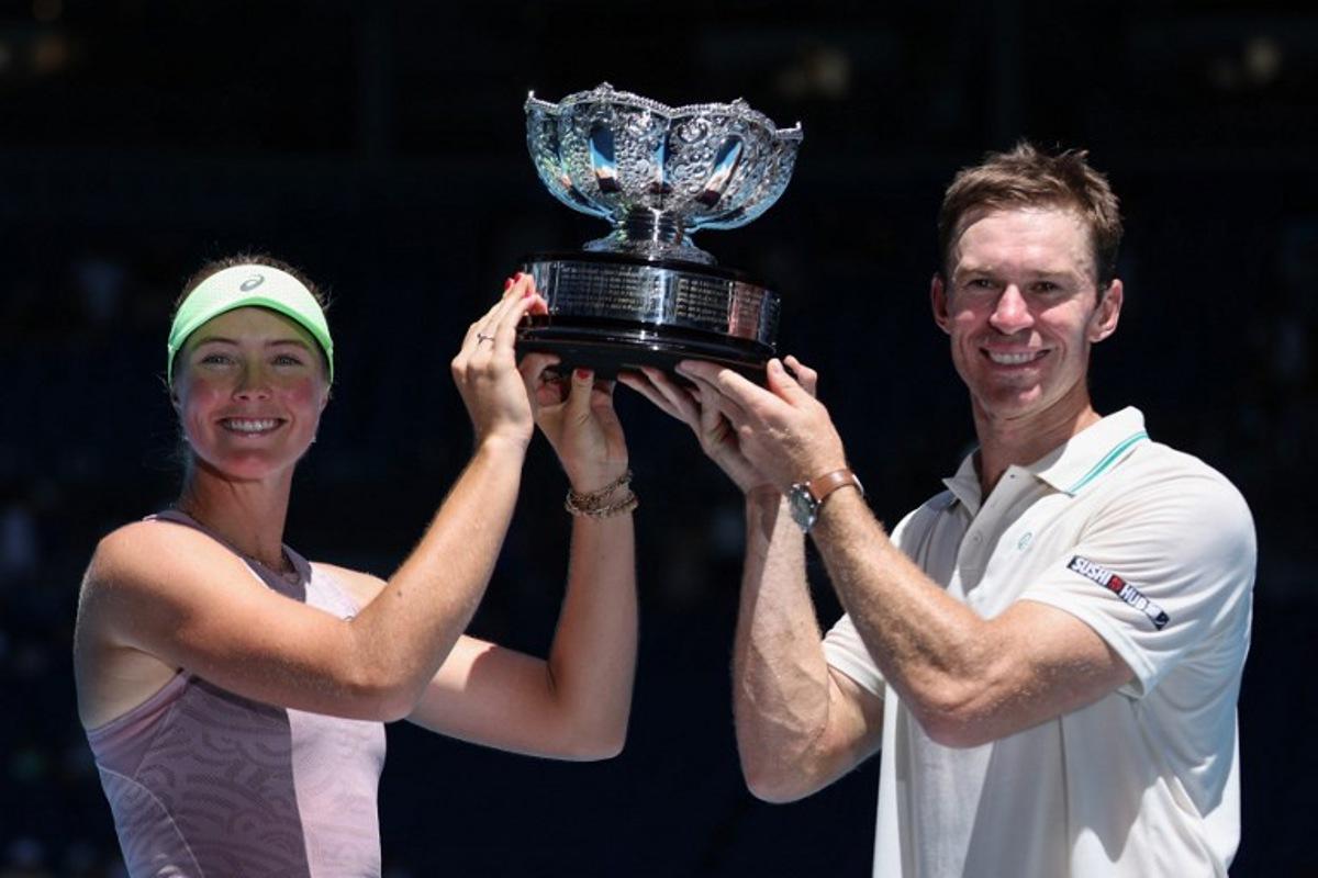 Australia's Olivia Gadecki and John Peers pose with the trophy after victory against France's Kristina Mladenovic and Manuel Guinard during their mixed doubles final match on day thirteen of the Australian Open tennis tournament in Melbourne on January 30, 2026. Martin KEEP / AFP