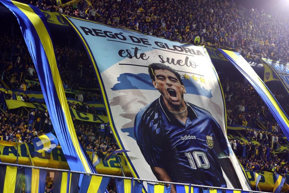 Boca Juniors' fans display a giant flag depicting Argentine football legend Diego Maradona during the Argentine Professional League 2026 Clausura tournament football match between Boca Juniors and Union de Santa Fe at La Bombonera stadium in Buenos Aires on October 2, 2026. Alejandro PAGNI / AFP