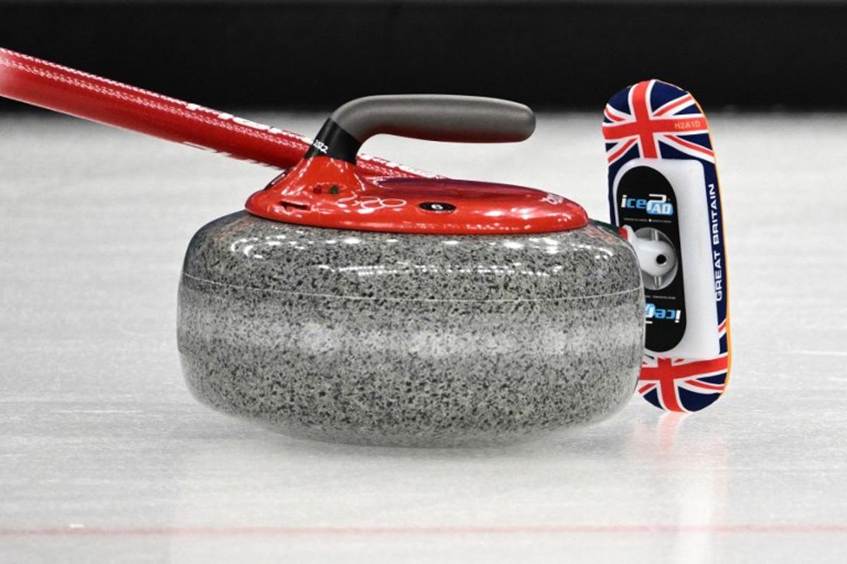 A detail shot of a curling stone and a curling broom during the women's gold medal game of the Beijing 2022 Winter Olympic Games curling competition between Japan and Great Britain at the National Aquatics Centre in Beijing on February 20, 2022. Jeff PACHOUD / AFP