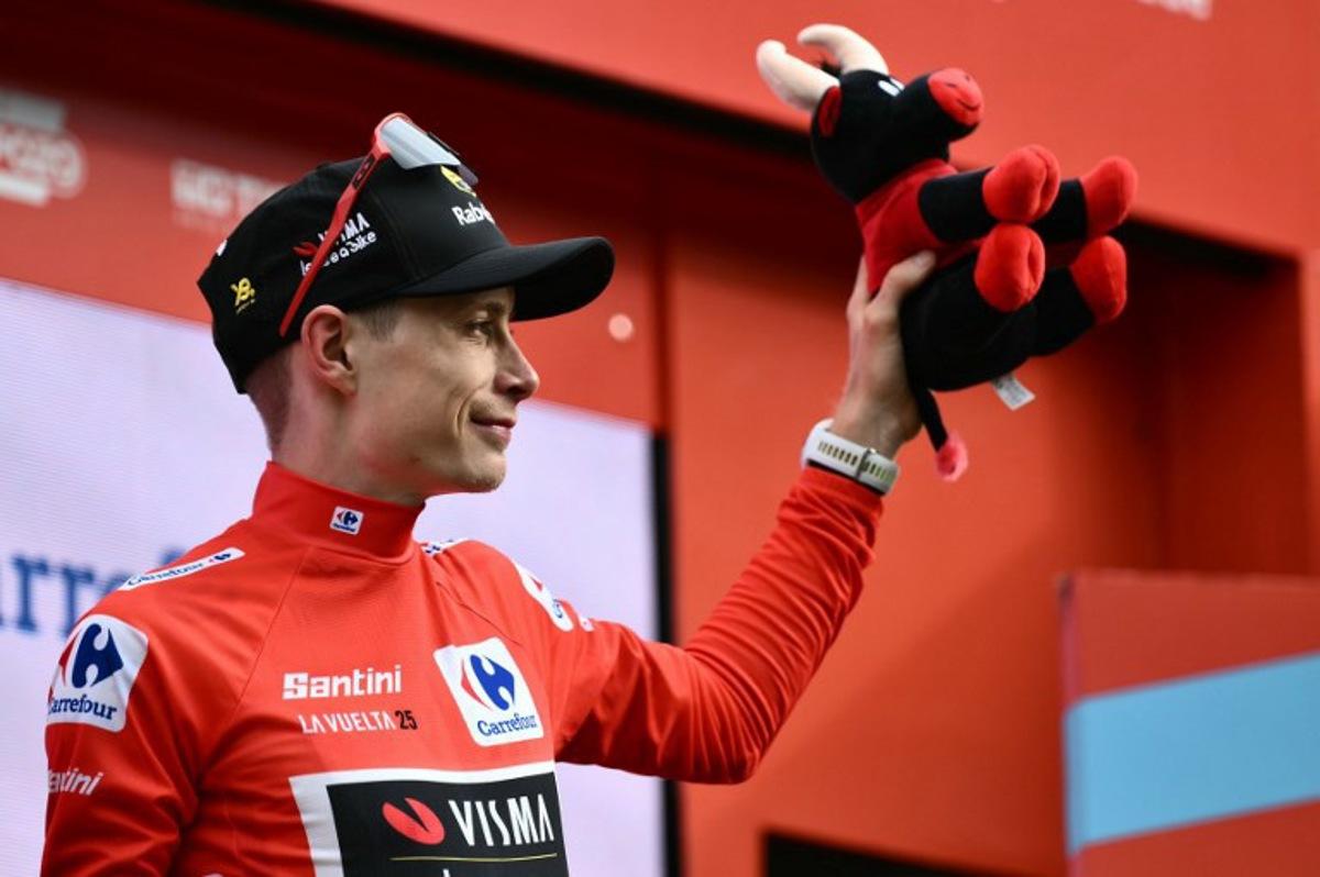 Team Visma-Lease a bike's Danish rider Jonas Vingegaard celebrates on the podium wearing the overall leader's red jersey after the third stage of the Vuelta a Espana, a 134 km race between San Maurizio Canavese and Ceres, in Italy's Piemonte region, on August 25, 2025. Marco BERTORELLO / AFP