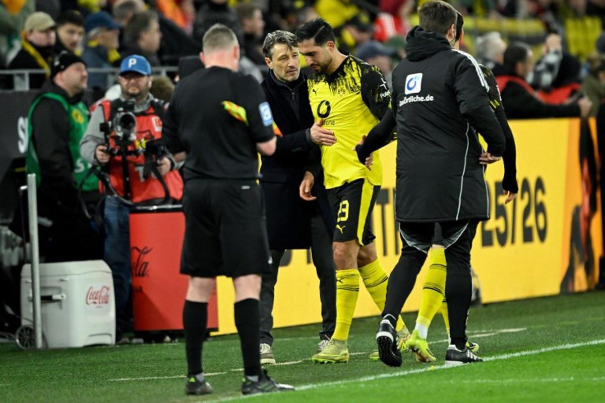 Dortmund's German midfielder #23 Emre Can (C) is consoled by Dortmund's Croatian head coach Niko Kovac as he goes off after sustaining an injury during the German first division Bundesliga football match between BVB Borussia Dortmund and FC Bayern Munich in Dortmund, western Germany, on February 28, 2026. INA FASSBENDER / AFP