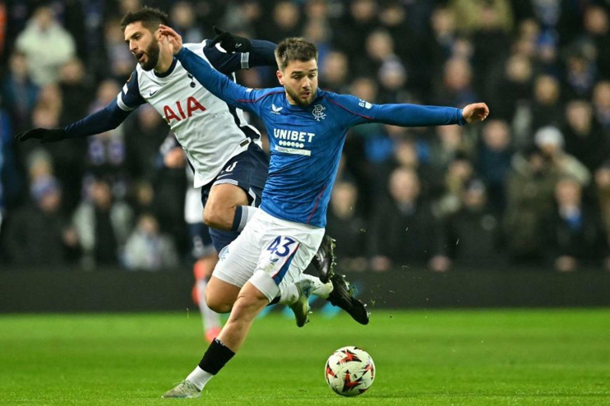 Rangers' Belgian midfielder #43 Nicolas Raskin fights for the ball with Tottenham Hotspur's Uruguayan midfielder #30 Rodrigo Bentancur during the UEFA Europa League, League Phase football match between Rangers and Tottenham Hotspur at the Ibrox Stadium in Glasgow on December 12, 2024. ANDY BUCHANAN / AFP