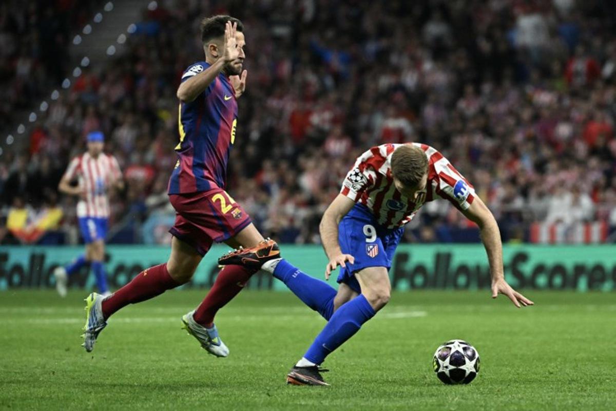 Atletico Madrid's Norwegian forward #09 Alexander Sorloth (R) falls to the ground after colliding with Barcelona's Spanish defender #24 Eric Garcia during the UEFA Champions League quarter final second leg football match between Club Atletico de Madrid and FC Barcelona at Metropolitano Stadium in Madrid on April 14, 2026. Javier SORIANO / AFP