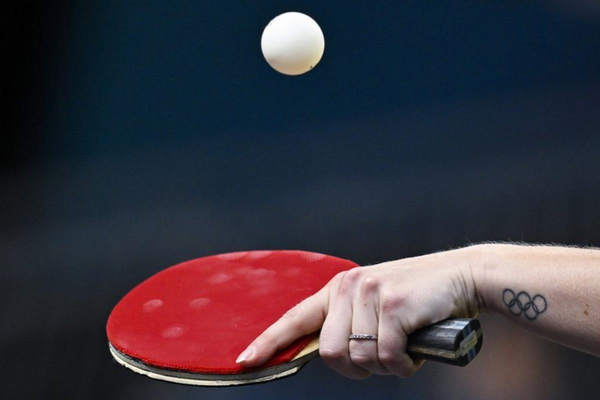 A tatoo depicting the Olympic rings is pictures on the wrist of Australia's Melissa Tapper as she plays against South Korea's Shin Yubin during their women's table tennis singles round of 64 at the Paris 2024 Olympic Games at the South Paris Arena in Paris on July 29, 2024. WANG Zhao / AFP