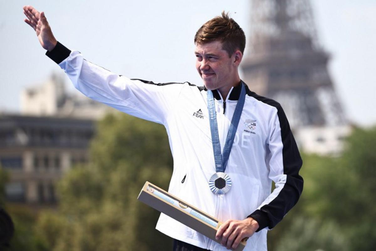 Silver medallist New Zealand's Hayden Wilde gestures on the podium during the victory ceremony for the men's individual triathlon at the Paris 2024 Olympic Games in central Paris on July 31, 2024. Anne-Christine POUJOULAT / AFP