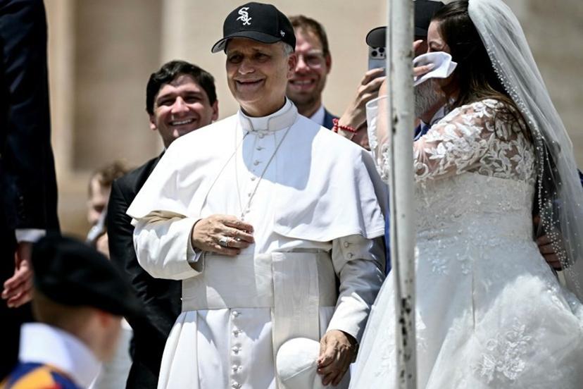 Pope Leo XIV (C) reacts wearing a Chicago White Sox baseball team cap as he meets newly wedded couples during the weekly general audience in St Peter's Square at the Vatican on June 11, 2025. Filippo MONTEFORTE / AFP