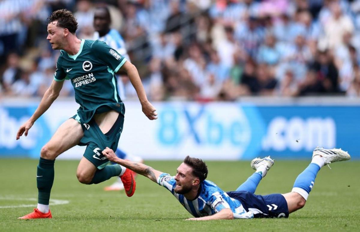 Coventry City's English midfielder #06 Matt Grimes (R) pulls on Brighton's Belgian defender #29 Maxim De Cuyper (L) as they vie for the ball during the English Premier League football match between Coventry City and Brighton and Hove Albion at the Coventry Building Society Arena in Coventry, central England on September 13, 2026. Henry NICHOLLS / AFP