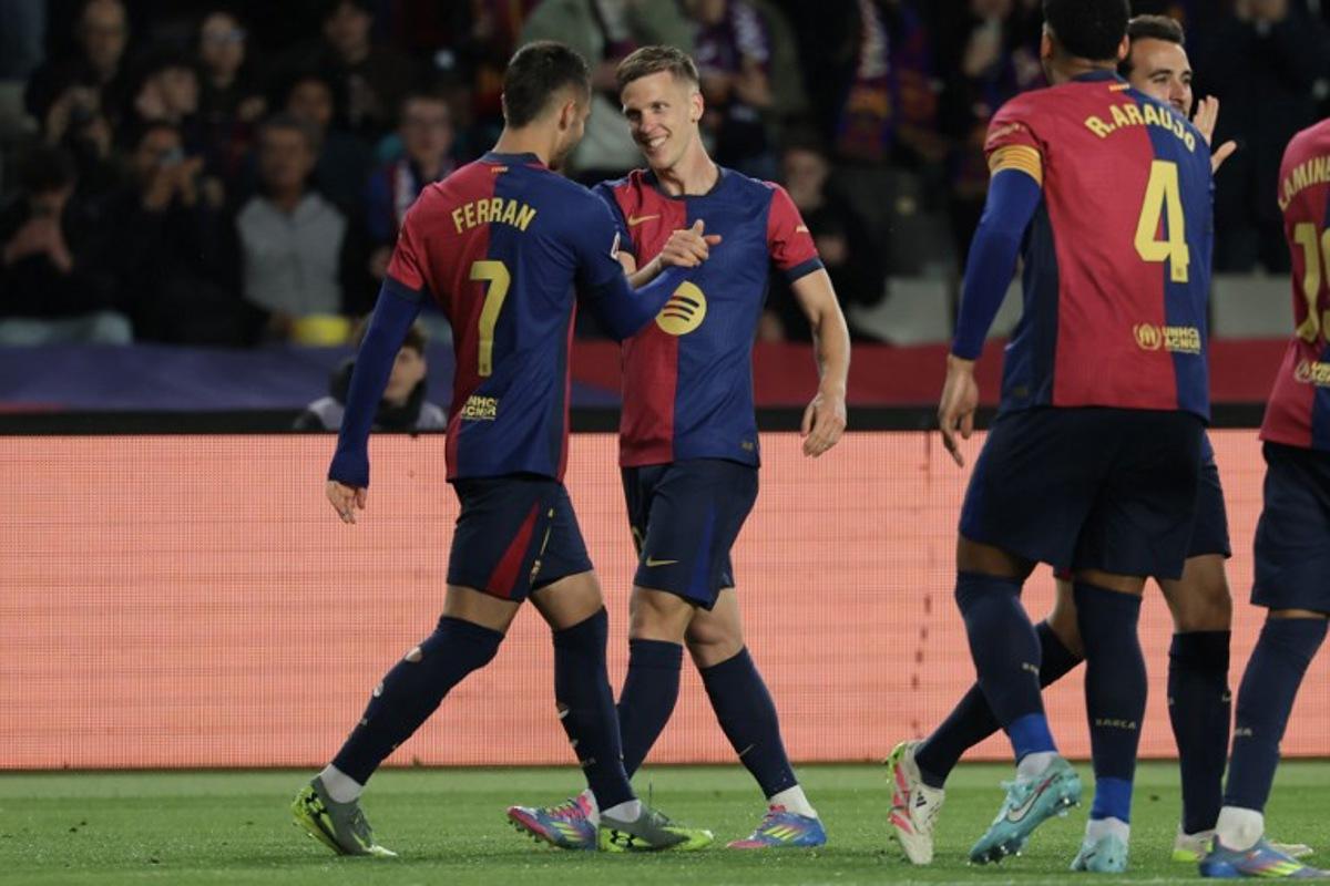 Barcelona's Spanish forward #20 Daniel Olmo (2L) celebrates with teammates after scoring his team's first goal during the Spanish league football match between FC Barcelona and RCD Mallorca at the Estadi Olimpic Lluis Companys in Barcelona, on April 22, 2025. LLUIS GENE / AFP