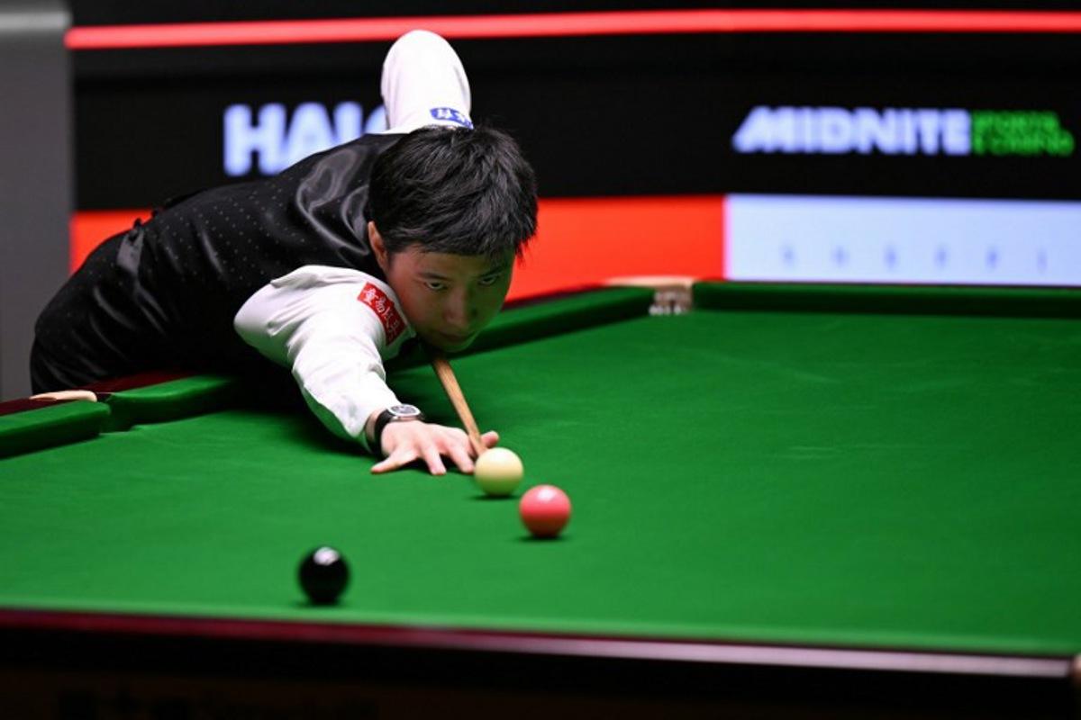 China's Zhao Xintong plays a shot on day two of his World Championship Snooker final against Wales' Mark Williams during the afternoon session at The Crucible in Sheffield, northern England on May 5, 2025. Oli SCARFF / AFP
