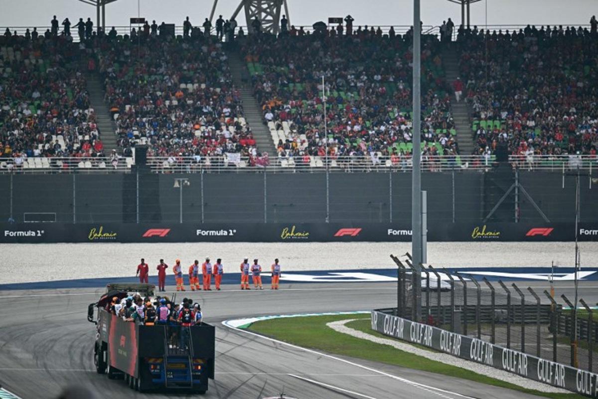 Supporters watch as drivers ride on a truck during the Driver's Parade ahead of the Formula One Bahrain Grand Prix in Sepang on October 4, 2026. Lillian SUWANRUMPHA / AFP