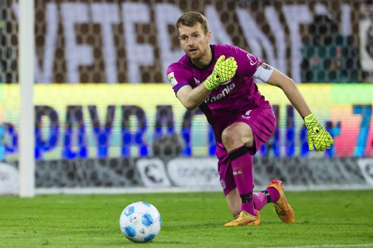 Bayer Leverkusen's Finnish goalkeeper #01 Lukas Hradecky passes the ball during the German first division Bundesliga football match between FC St Pauli and Bayer 04 Leverkusen in Hamburg, northern Germany on April 20, 2025. FRANK MOLTER / AFP