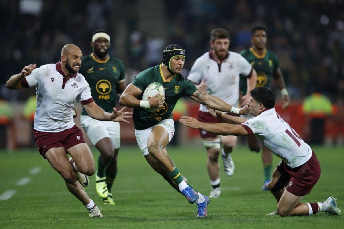 South Africa's wing Edwill van der Merwe runs away from Georgia's centre Demuri Tapladze (L) and Georgia's fly-half Luka Matkava (R) during the international rugby union Test match between South Africa and Georgia at Mbombela Stadium in Mbombela on July 19, 2025. PHILL MAGAKOE / AFP