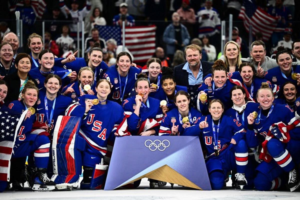 Gold medallists USA pose during the medals ceremony for the women's ice hockey event at the Milano Santagiulia Ice Hockey Arena during the Milano Cortina 2026 Winter Olympic Games in Milan, on February 19, 2026. JULIEN DE ROSA / AFP