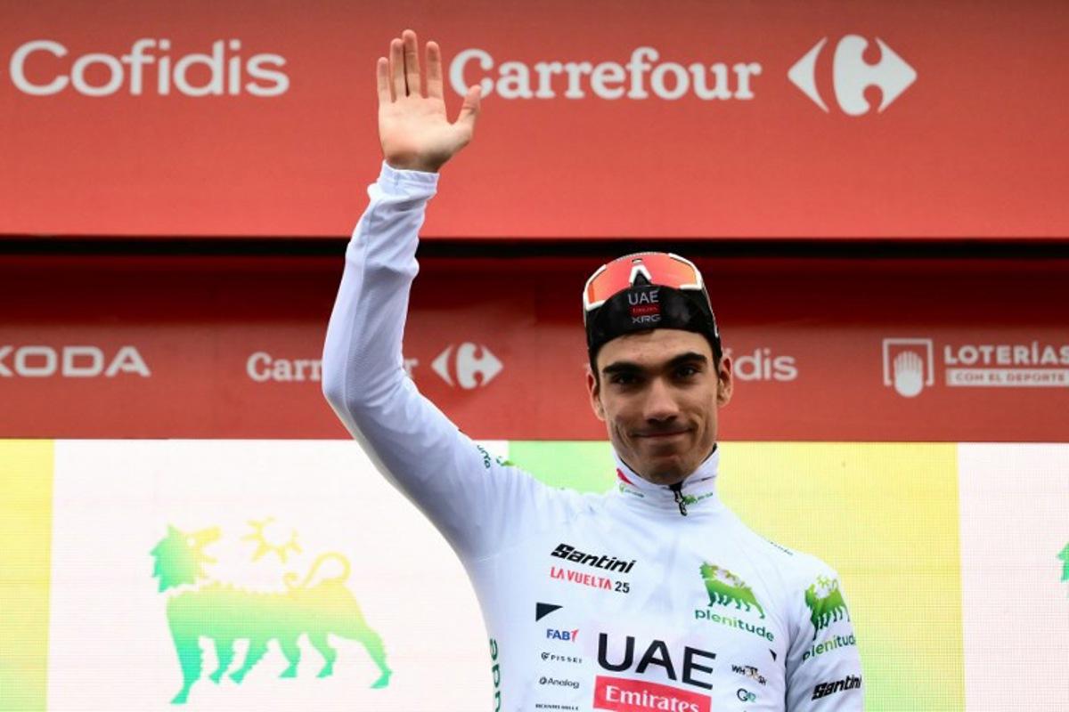 Team UAE's Spanish rider Juan Ayuso. wearing the best youth's white jersey, poses on the podium after the second stage of the Vuelta a Espana, a 159,6 km race between Alba and Limone Piemonte, in Italy's Piemonte region, on August 24, 2025. Marco BERTORELLO / AFP