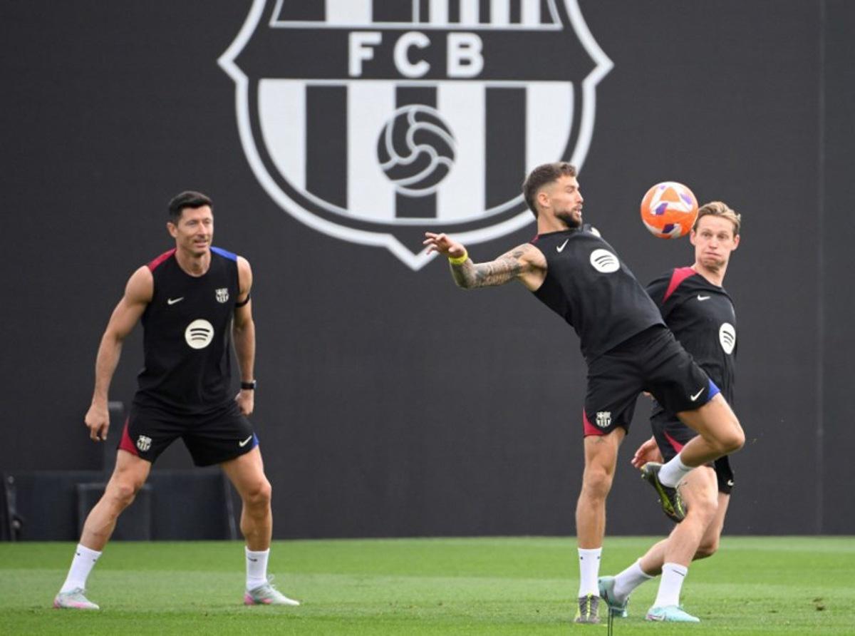 (From L) Barcelona's Polish forward #09 Robert Lewandowski, Barcelona's Spanish defender #05 Inigo Martinez Berridi, Barcelona's Dutch midfielder #21 Frenkie De Jong take part in a training session on the eve of the Spanish league football match between FC Barcelona and Real Madrid CF, at the Joan Gamper training ground in Sant Joan Despi, near Barcelona, on May 10, 2025. Josep LAGO / AFP