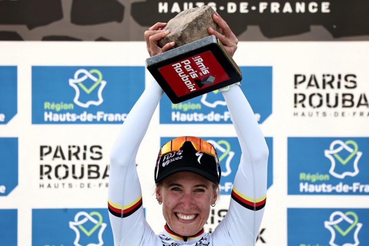 FDJ United-SUEZ's German rider Franziska Koch celebrates winning on the podium of the 6th edition of the Women Paris-Roubaix one-day classic cycling race, 143.1 km between Denain and Roubaix, at the Vélodrome André-Pétrieux in Roubaix, northern France, on April 12, 2026. Anne-Christine POUJOULAT / AFP