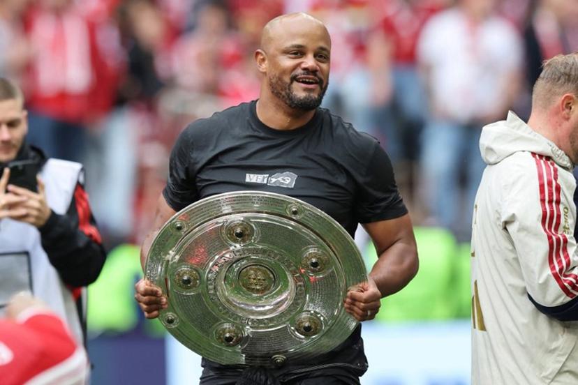 Bayern Munich's Belgian head coach Vincent Kompany walks with the trophy in his hands after a beer shower during celebrations after the German first division Bundesliga football match between FC Bayern Munich and FC Cologne in Munich, southern Germany, on May 16, 2026. Alexandra BEIER / AFP