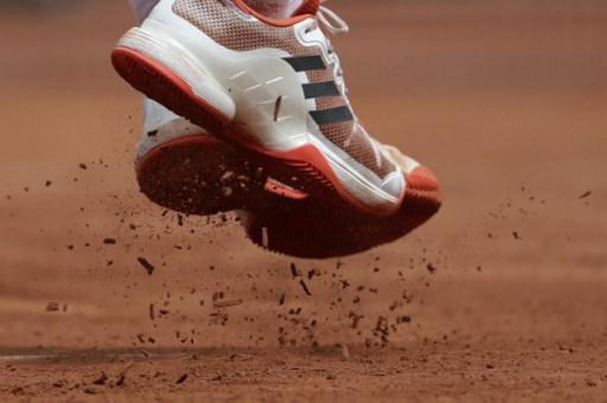 A photo shows clay from the court falling of the shoes of Austria's Dominic Thiem as he returns the ball to Serbia's Novak Djokovic at the Roland Garros 2017 French Open on June 7, 2017 in Paris. Thomas SAMSON / AFP