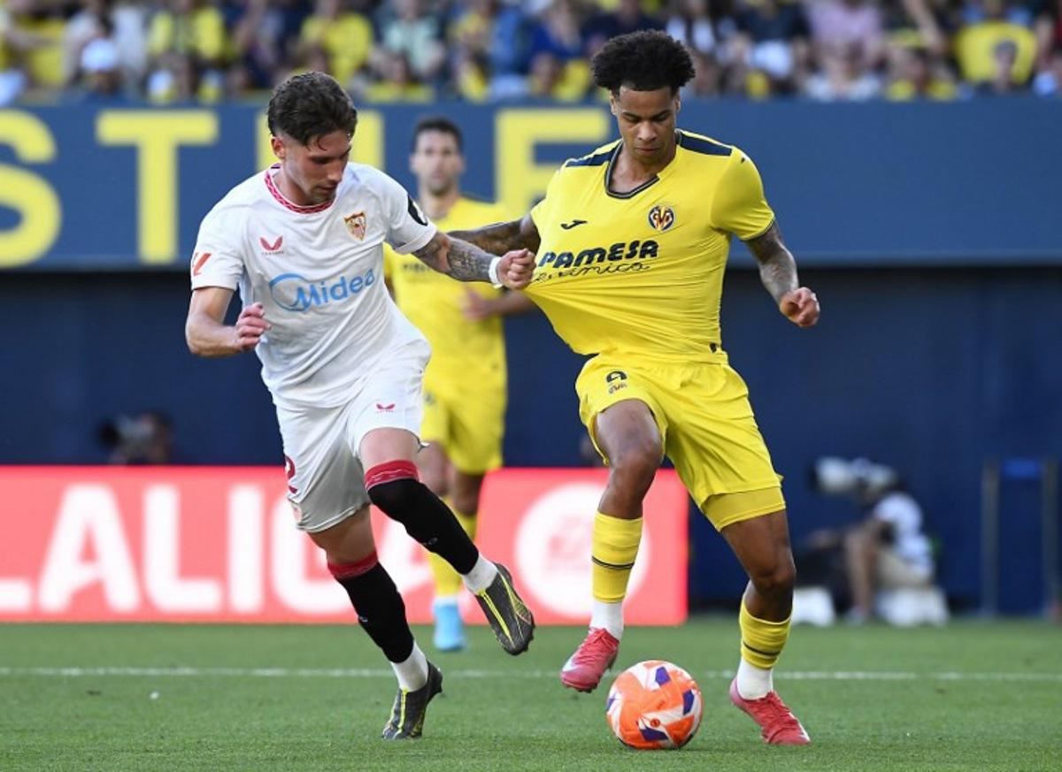Sevilla's Spanish defender #02 Jose Carmona grasps Villarreal's Canadian midfielder #09 Tajon Buchanan's jersey during the Spanish league football match between Villarreal CF and Sevilla FC at La Ceramica Stadium in Vila-real, on May 25, 2025. Jose Jordan / AFP