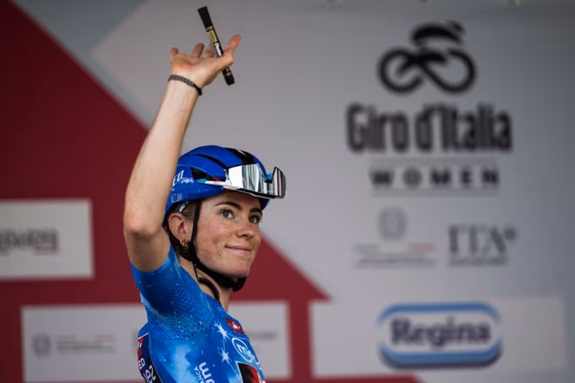 FDJ Suez's Dutch cyclist Demi Vollering, wearing the best climber's blue jersey (Maglia Azzurra), waves during the pre-stage presentation ahead of the 9th stage of the Giro d'Italia Women 2026 between Saluzzo and Saluzzo in Saluzzo on June 7, 2026. MARCO BERTORELLO / AFP