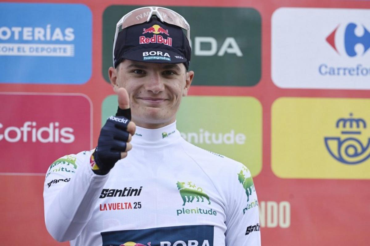 Team Bora's Italian rider Giulio Pellizzari celebrates on the podium retaining the best youth white jersey after the 14th stage of the Vuelta a Espana cycling tour, a 135 km race between Aviles and La Farrapona in Somiedo, on September 6, 2025. Miguel RIOPA / AFP