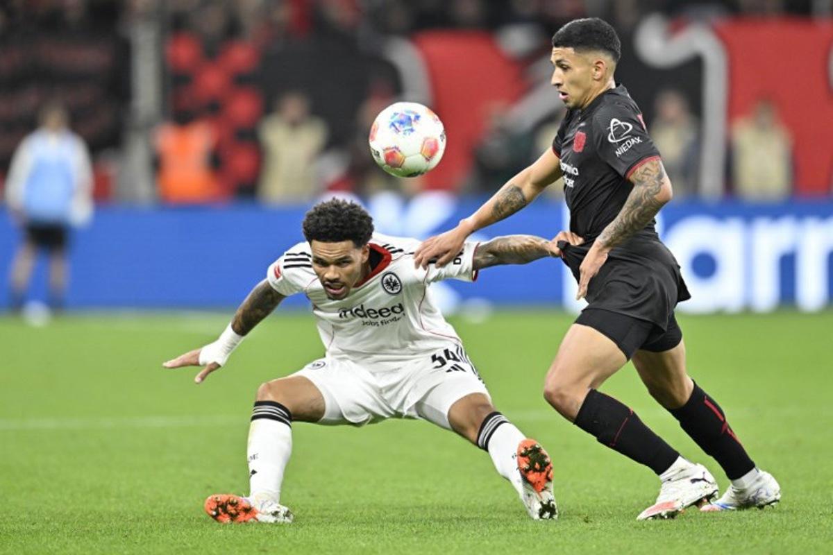 Frankfurt's German-Nigerian defender #34 Nnamdi Collins (L) and Bayer Leverkusen's Argentinian midfielder #06 Ezequiel Fernandez vie for the ball during the German first division Bundesliga football match between Bayer 04 Leverkusen and Eintracht Frankfurt in Leverkusen, western Germany on September 12, 2025. INA FASSBENDER / AFP