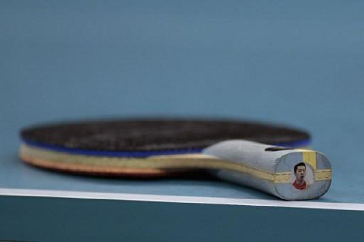 China's Ma Long's racket is seen on the table with his own picture on the end in the men's team gold medal table tennis match against Japan's Maharu Yoshimura at the Riocentro venue during the Rio 2016 Olympic Games in Rio de Janeiro on August 17, 2016.
Juan Mabromata / AFP