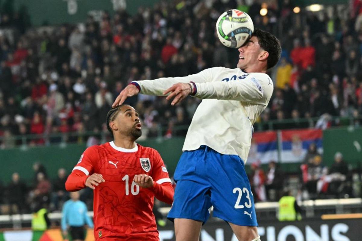 Austria's defender #16 Philipp Mwene and Serbia's forward #23 Dusan Vlahovic vie for the ball during the UEFA Nations League play-off, first-leg football match Austria v Serbia at the Ernst Happel Stadium in Vienna on March 20, 2025. Joe Klamar / AFP