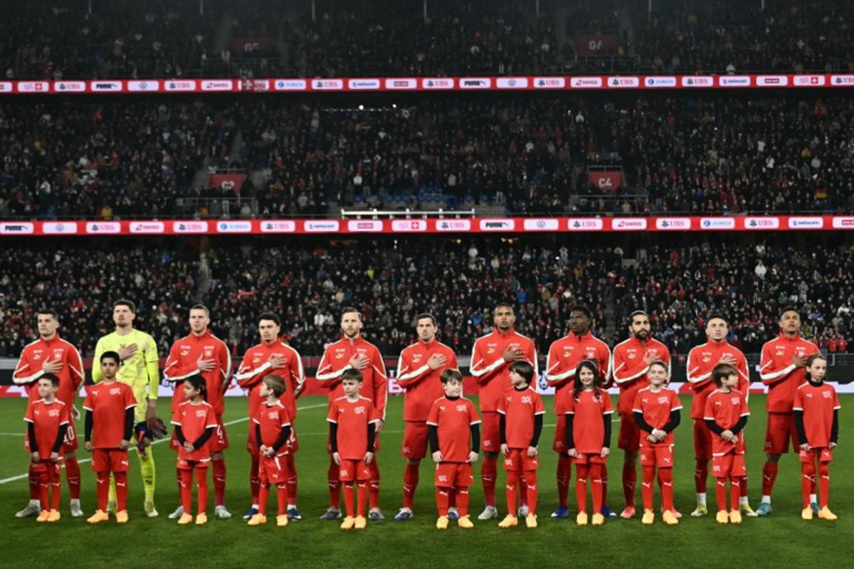 Switzerland's starting squad stands on the pitch for national anthems ahead of the start of the international friendly football match between Switzerland and Germany at St. Jakob-Park in Basel, Switzerland on March 27, 2026. Fabrice COFFRINI / AFP